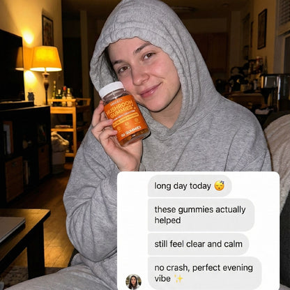 Person in a gray hoodie holding a jar of gummies in a living room.